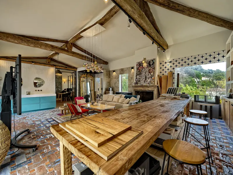 L'agence CRD Habitat : la grande table en chêne massif sous la charpente apparente, le salon et la cuisine d'exposition
