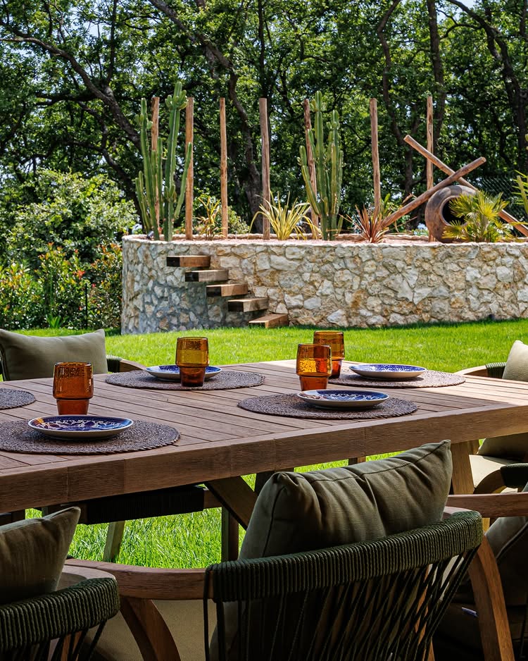 Table dressée sur une terrasse en pierre, prête pour l'arrivée des propriétaires