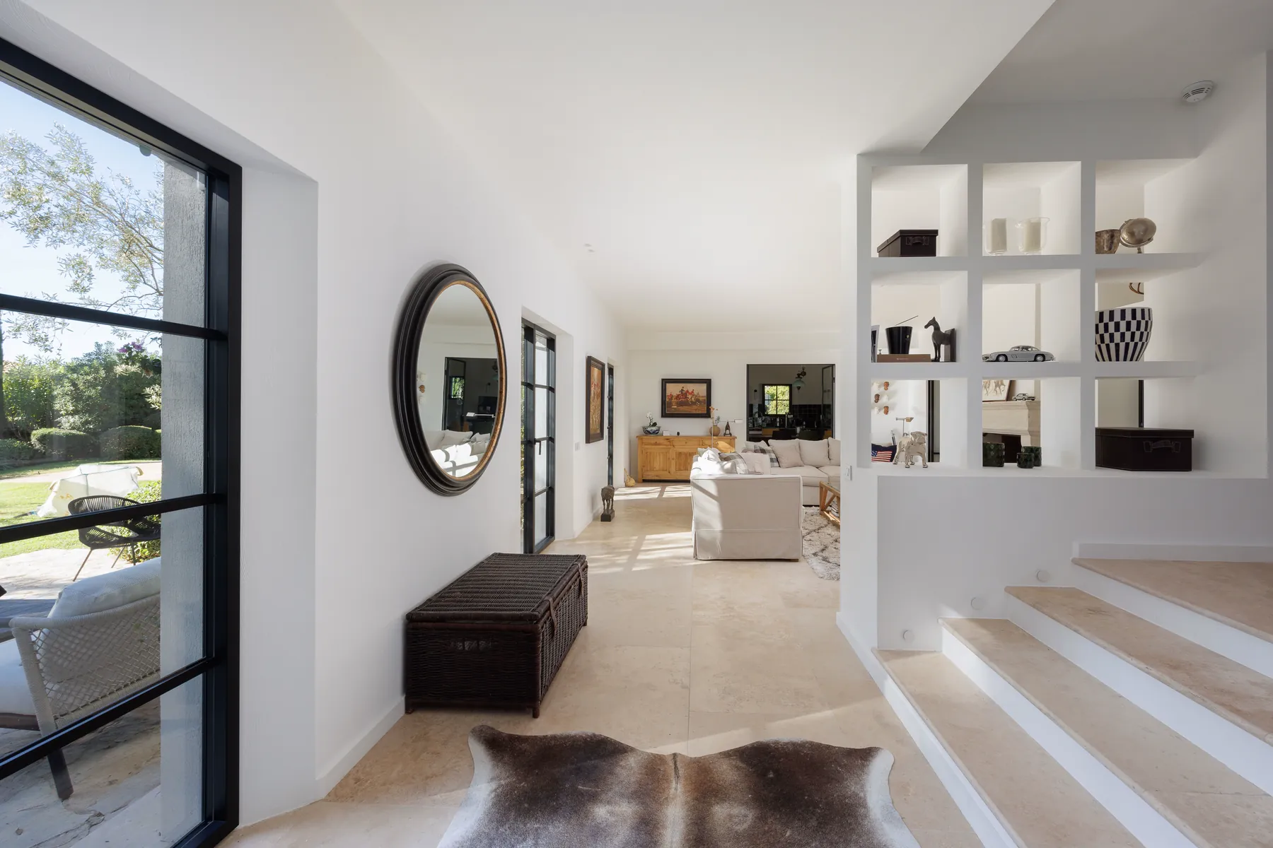 Villa STAN : l'entrée traversante, ses verrières d'acier noir, le claustra de niches et les marches de pierre claire