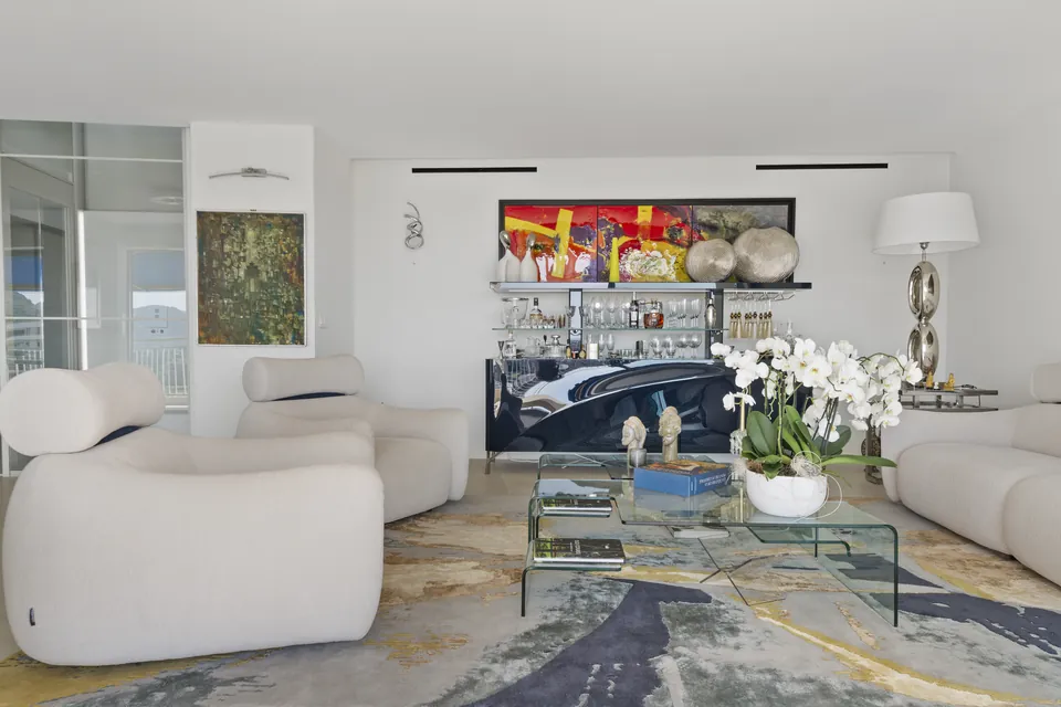 Appartement Aurea — Le salon, les matières claires et le mobilier aux courbes généreuses