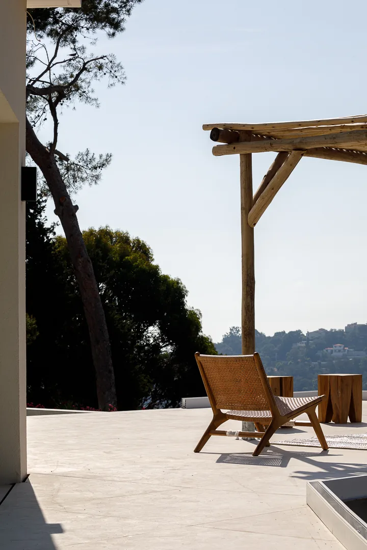 Terrasse avec fauteuil en bois, pergola et vue sur le paysage méditerranéen