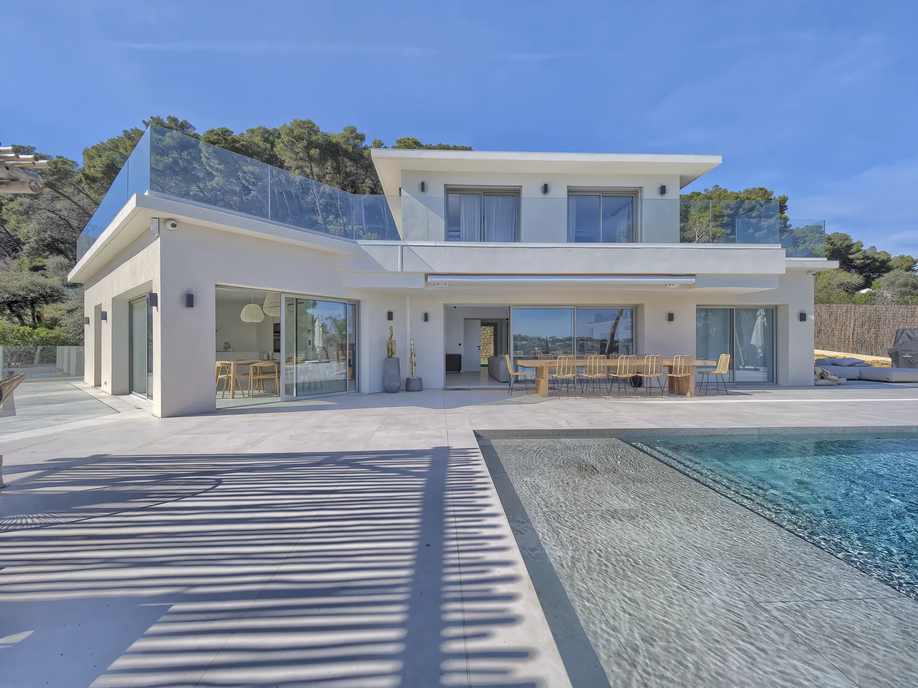 Villa Azur : la façade blanche et le bassin miroir bordé de pierre